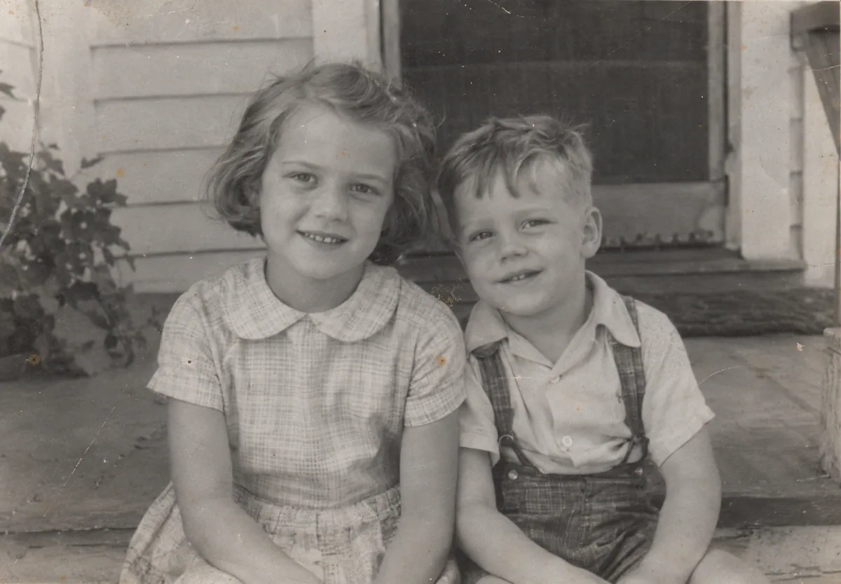 Siblings on the porch, original aged photo (illustrative)